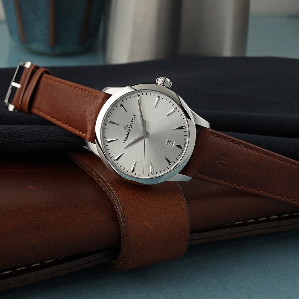 Men's minimalist analog watch with silver sunburst dial, brown leather strap, and silver-tone stainless steel case